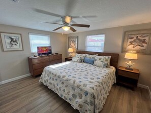 A bedroom with a bed, a dresser, a television, and a ceiling fan. - Casa Blanca - Villa D05 (Sarasota)