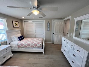 A bedroom with a bed, dresser, and a ceiling fan. - Casa Blanca  -Villa C15 (Sarasota)