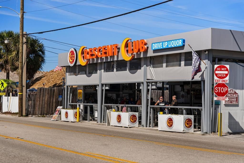 A Crescent Club Drive Up Liquor with a drive-thru service, a pedestrian crossing sign, and a 'Do Not Enter' sign.
