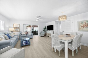 A spacious living area with a dining table, sofas, and a television. - Casa Blanca Villa A11 (Sarasota)