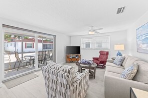 A modern living room with a sofa, armchairs, a TV, and a ceiling fan. - Casa Blanca - Villa C03 (Sarasota)