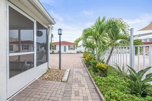 A residential property with a paved walkway, a hanging flower basket, and a street lamp. - Casa Blanca - Villa B01 (Sarasota)