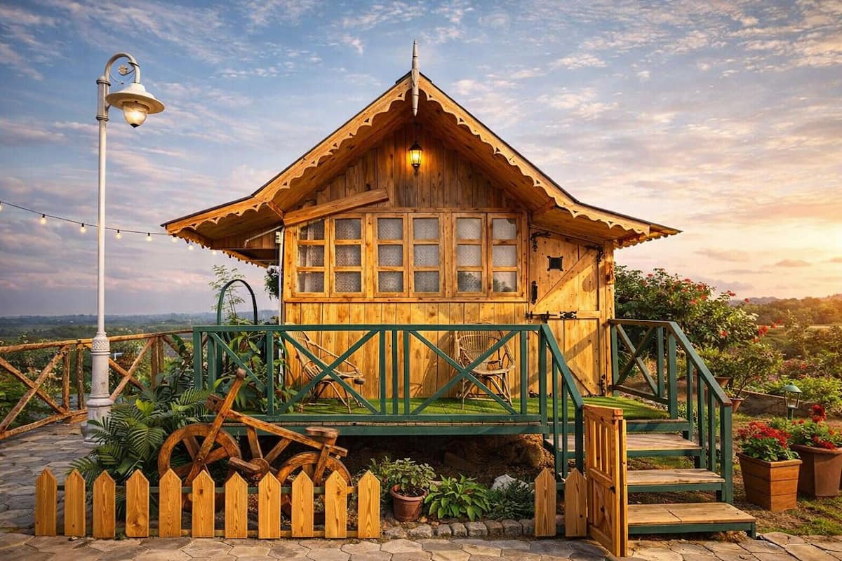 A wooden cabin with a balcony, a wooden fence, and a lamp post.