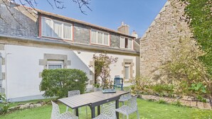 A house with a stone wall, a grassy yard, and a table with chairs. - House for 4 adults 2 kids, walk everywhere (Ile Tudy)