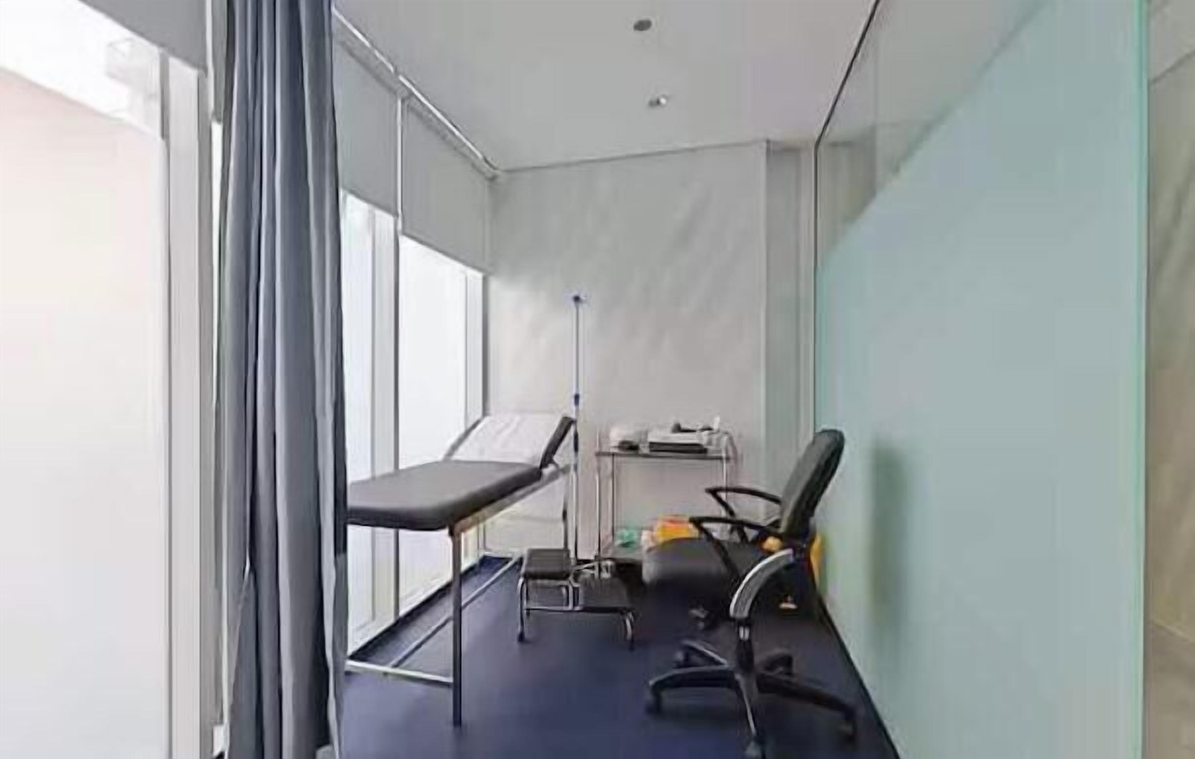 A room with a bed, a desk, a chair, and a window.