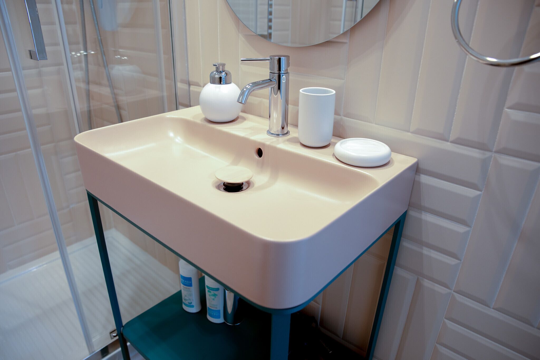 A bathroom with a sink, faucet, and mirror.