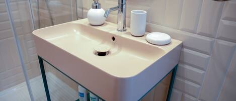A bathroom with a sink, faucet, and mirror.