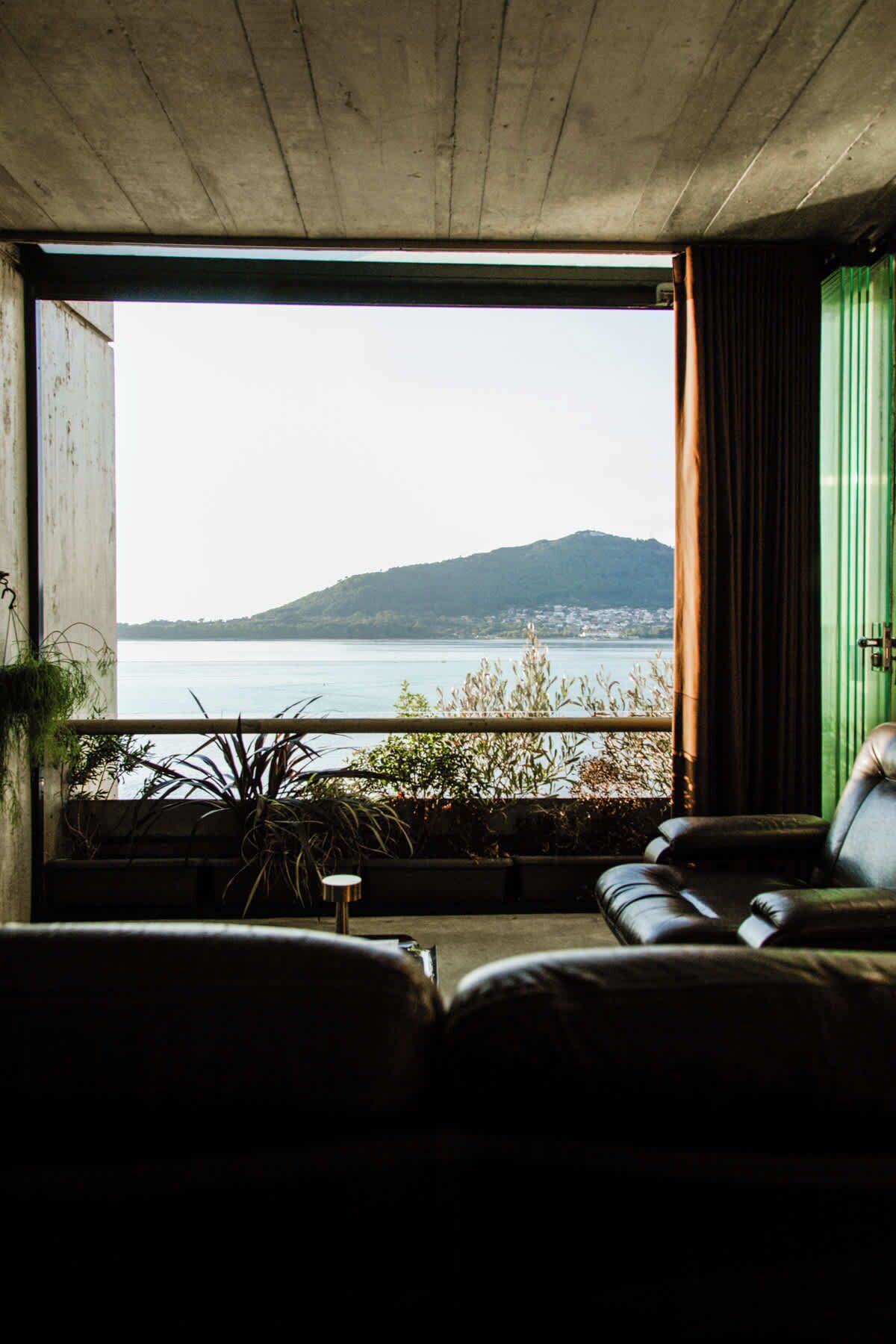 A room with a view of a body of water and a distant mountain.