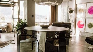 A spacious living room with a large round table, a chandelier, and a cowhide rug. - Luxury Waterfront Loft with Panoramic Views (Caminha)
