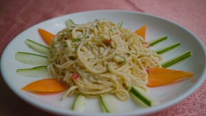 A plate of noodles with vegetables. - Green House Hotel And Suites (Lagos)
