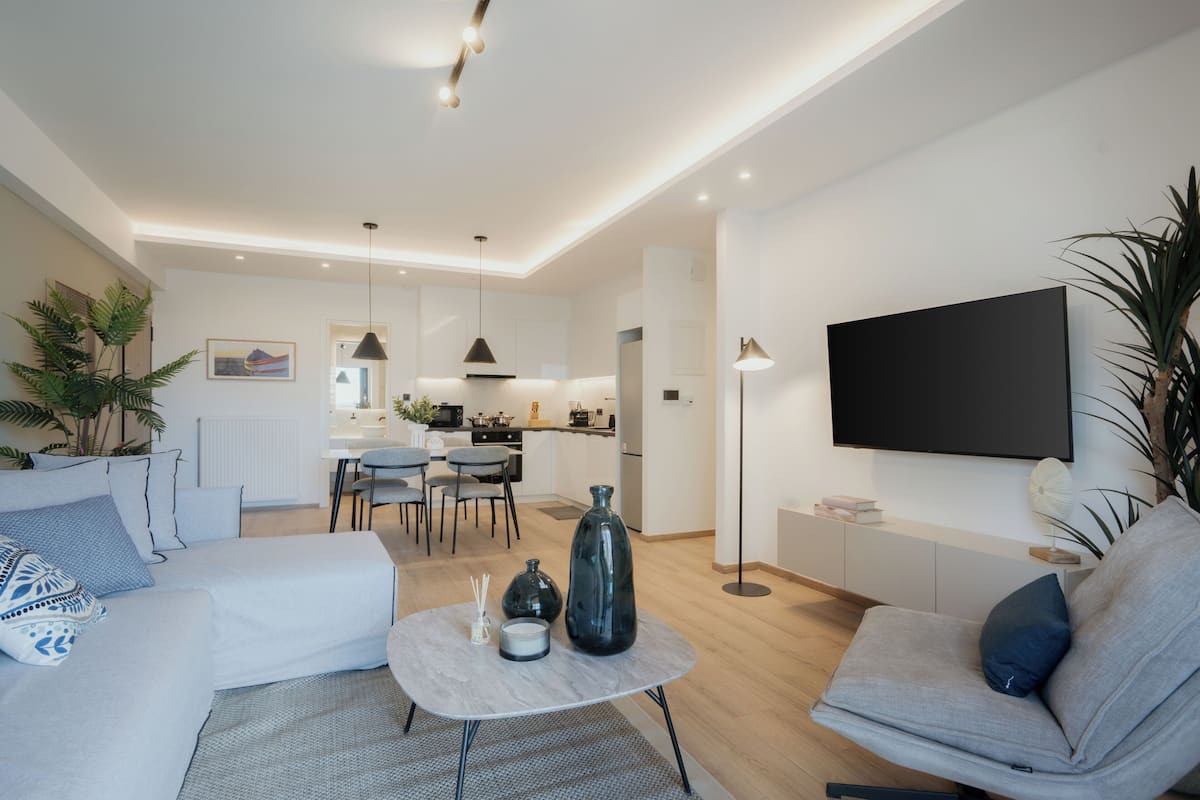 A modern living room with a sofa, coffee table, and a flat-screen TV.