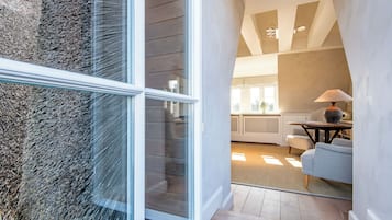 Un interior moderno con una puerta de vidrio que da a una sala de estar, una chimenea y una mesa de comedor.