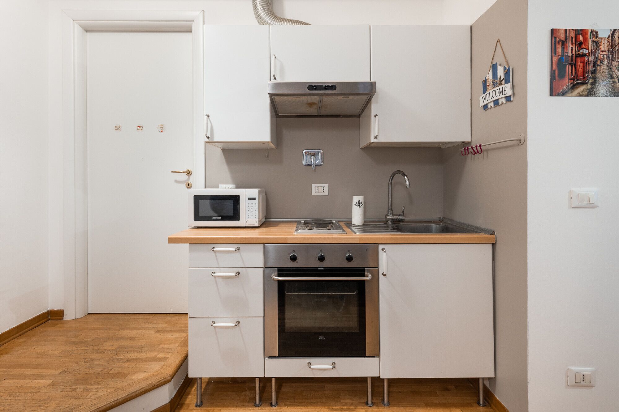 A compact kitchen with a microwave, stove, oven, and sink.