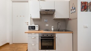 A compact kitchen with a microwave, stove, oven, and sink. - Nido di Galliera by Wonderful Italy (Bologna)