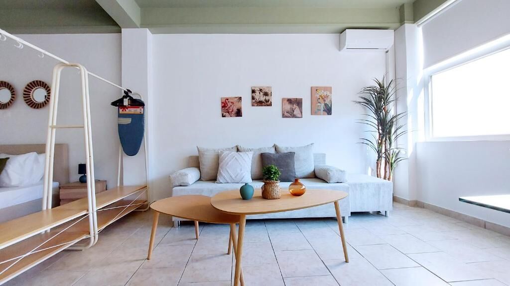 Un salon moderne avec un canapé, une table basse, une échelle et des œuvres d’art murales.