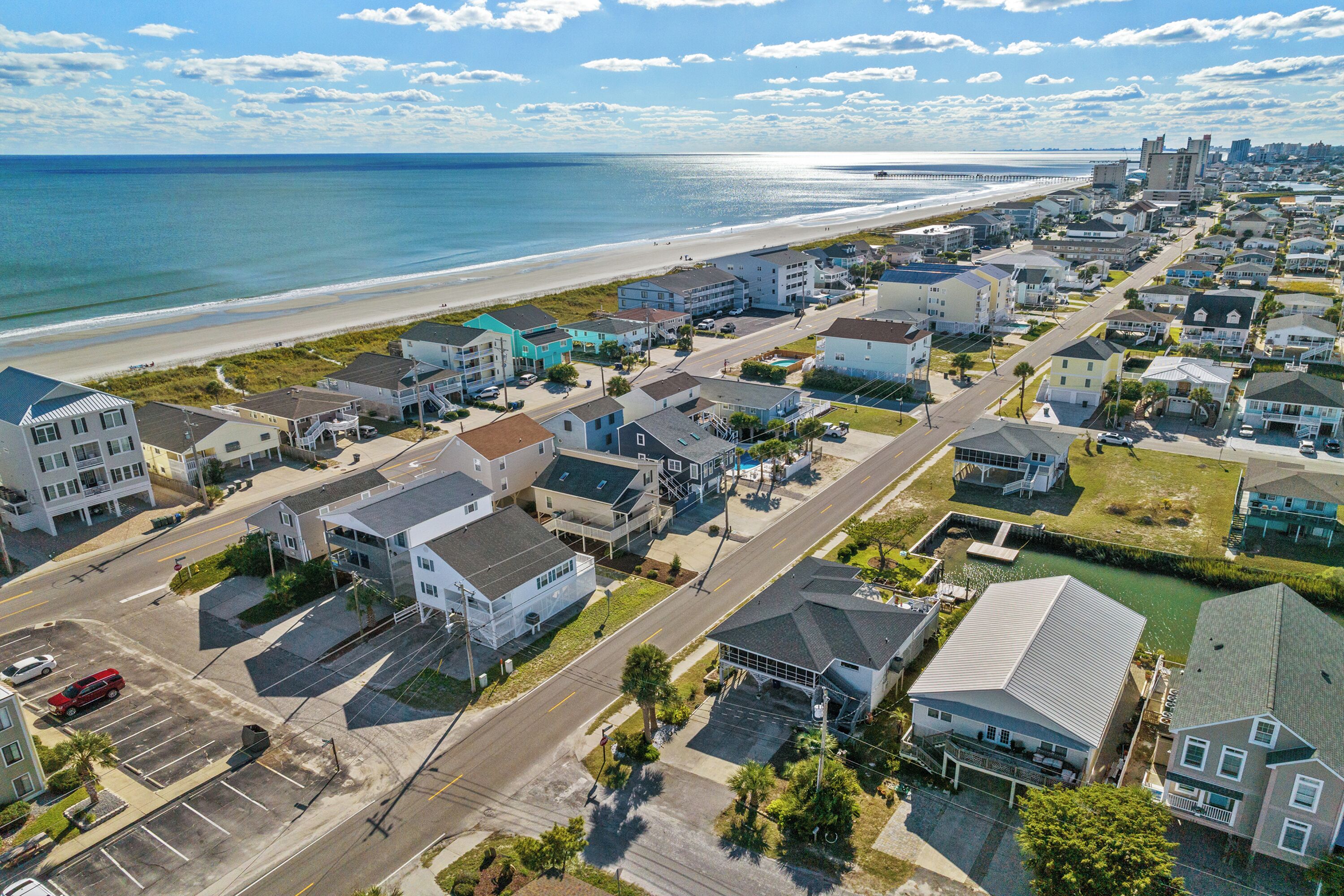 A coastal residential area with houses, a beach, and a marina.