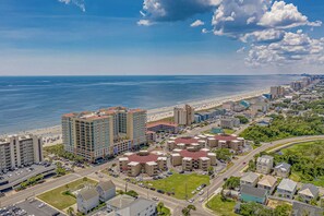 A coastal cityscape with a beachfront hotel, a highway, and surrounding residential buildings. - 2 bedroom oceanfront condo in Cherry Grove. Peaceful getaway! (North Myrtle Beach)