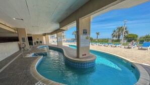 Ett poolområde med en skylt som anger poolens öppettider och en skylt med regler för "Lazy River" (en sorts lugn ström i poolen).