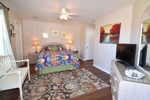 A bedroom with a bed, bedside lamps, a television, a desk, and a chair. - 2BR 2BA condo 2 blocks from beach. Easy beach access. Pool. (North Myrtle Beach)