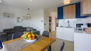 Un appartement moderne comprenant un coin repas, une cuisine et un salon.