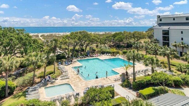 A resort with a large pool, palm trees, and a view of the ocean. - Oceanfront Penthouse with Sweeping Atlantic Views | Wild Dunes | Isle of Palms (Isle of Palms)