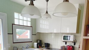 A kitchen with a central island, a microwave, a toaster, and a coffee maker. - Seaside Holiday Home: Spacious, Welcoming, Garden, Wi-Fi (Pornic)