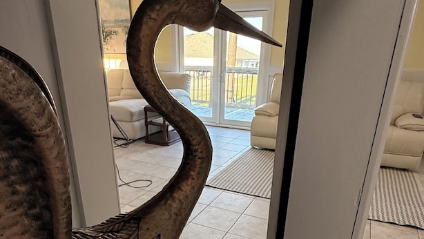 A swan sculpture in a hallway leading to a room with a view of a balcony. - Stunning Mobile Bay views near Dauphin Island (Coden)