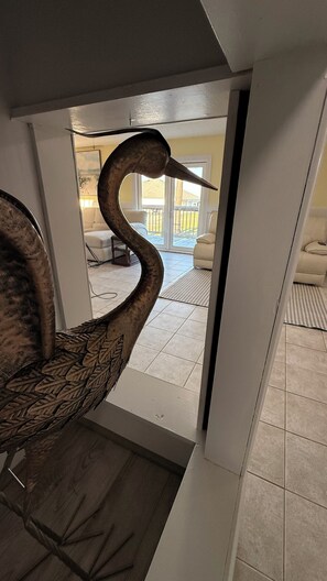 A swan sculpture in a hallway leading to a room with a view of a balcony. - Stunning Mobile Bay views near Dauphin Island (Coden)