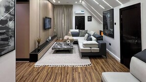 Una sala de estar moderna con un sofá, una mesa de centro y un televisor montado en la pared.