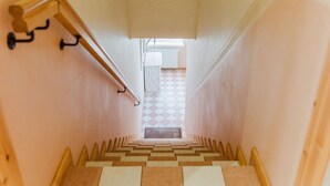 Eine Treppe mit Schachbrettmuster führt zu einem Raum mit einem Fenster.