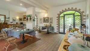 A dining area with tables set for a meal, a large arched doorway, and framed artwork on the walls. - Lovely room for 4 people with A/C, pool, WIFI, TV, veranda and pets allowed, close to Perugia (Agello)