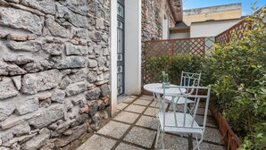 A stone wall, a metal gate, and a small patio with a table and chairs. - 'Vitali Home' - Apartment in the Heart of Catania (Catania)