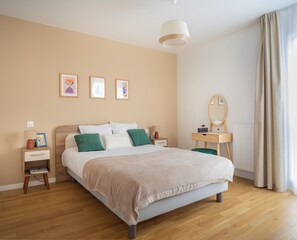 Ein Schlafzimmer mit Bett, Nachttischen, einem Schminktisch und einem Spiegel, sowie Bildern an der Wand.