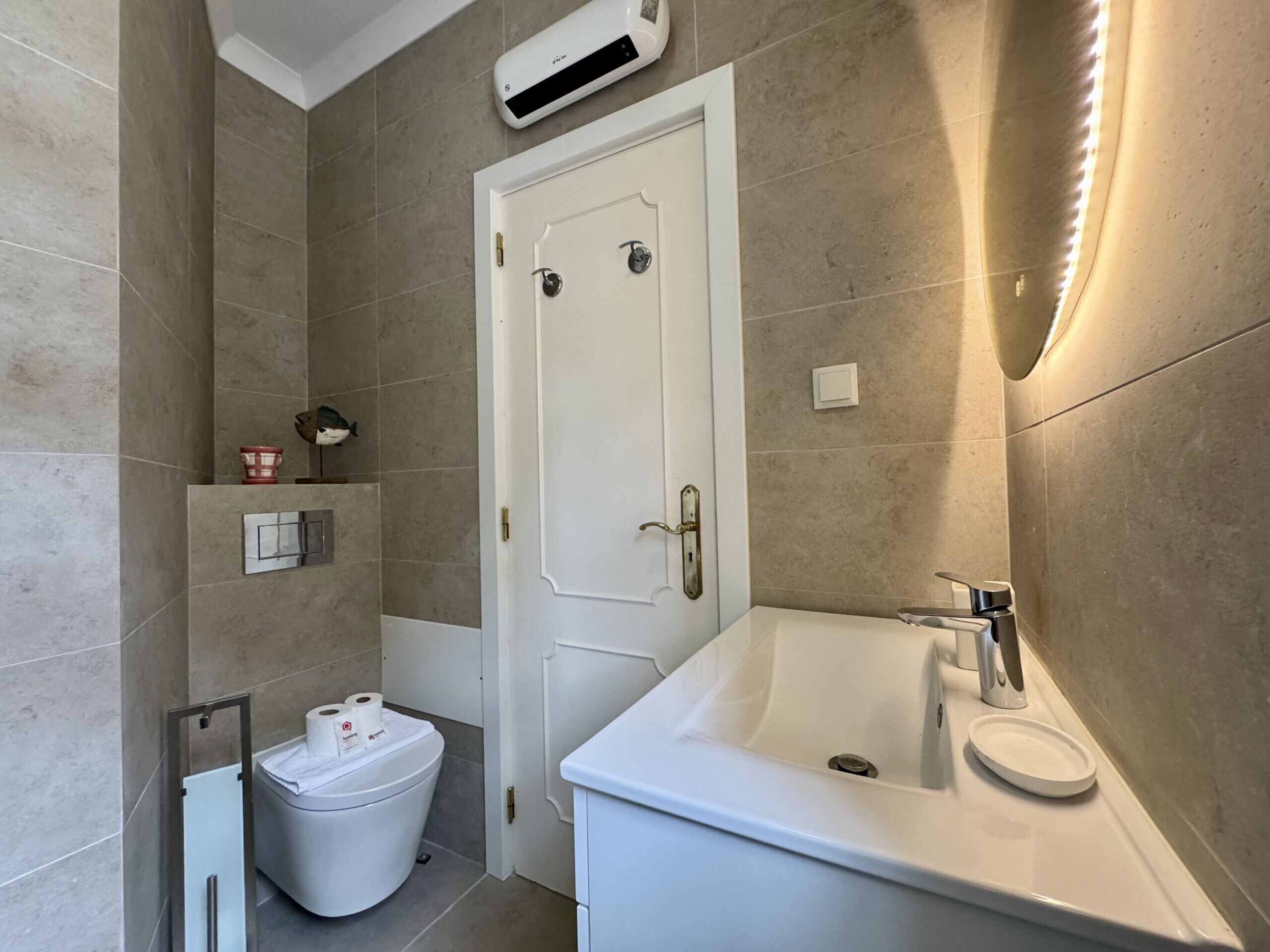 Une salle de bain équipée de toilettes, d’un lavabo et d’une douche.