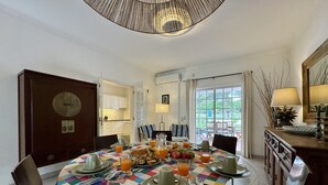 A dining area with a checkered tablecloth, breakfast items, and a view of the outdoors. - Vilamoura Summer Villa 3 by Homing (Loulé)