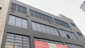 Un edificio con múltiples ventanas y un cartel anunciando VIRGO CROMA PREMIUM LAMINATES.