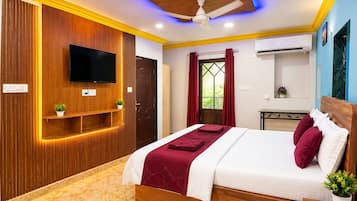 A modern bedroom with a bed, a television, a ceiling fan, and a window with curtains.
