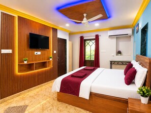 Un dormitorio moderno con una cama, un televisor, un ventilador de techo y una ventana con cortinas.