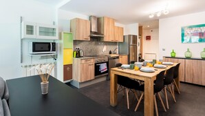 A modern kitchen with a dining area, featuring a microwave, stove, and cabinets.