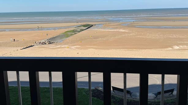 A beach view with a wooden railing, a grassy area, and a bench. - Charming apartment, sea view - 4 guests (Cabourg)