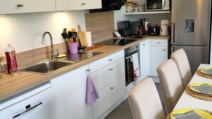 Una cocina moderna equipada con lavavajillas, pileta, microondas y refrigerador.
