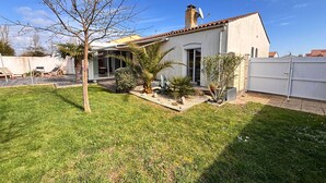 A residential house with a patio, a covered outdoor seating area, and a fenced backyard. - House with enclosed garden and veranda (LES SABLES D'OLONNE)