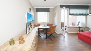 Ein Essbereich mit einem Holztisch, Stühlen und einem roten Sofa.