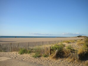 A beach with a wooden fence, sandy dunes, and a clear sky. - Beachside Getaway: 3-Bedroom House, Pet-Friendly, Near St-Pierre-La-Mer Beach (Fleury-Saint-Pierre-la-Mer)