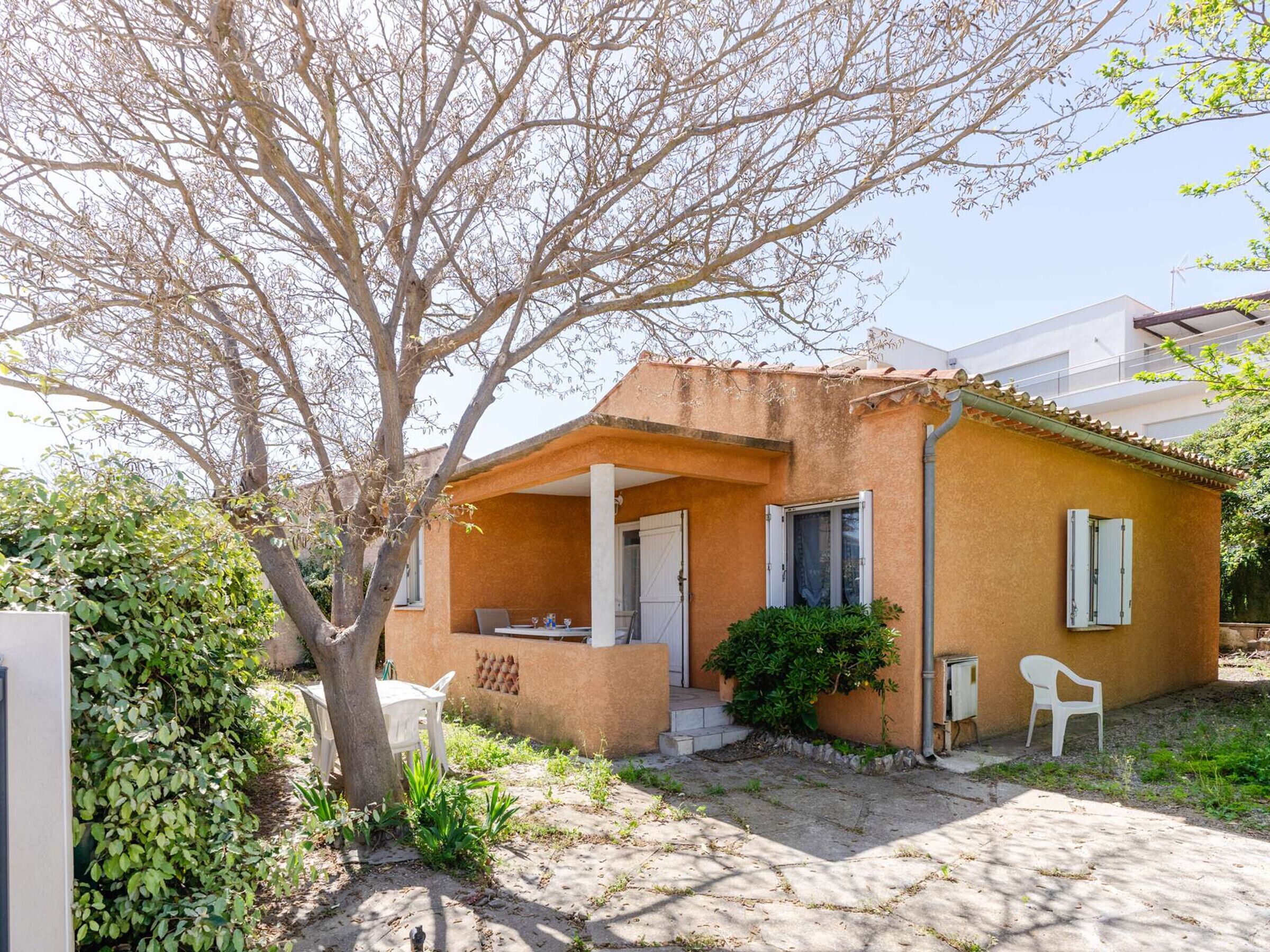 Une petite maison avec un porche, une porte et une fenêtre.