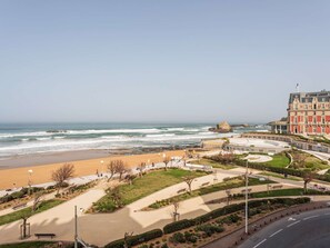 A coastal promenade with a beach, a circular plaza, and a large building with classical architecture. - Renovated studio, ocean view (Biarritz)