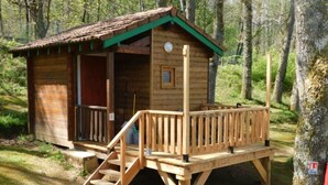 A wooden cabin with a porch, a small window, and a door. - Chalet with Terrace, Sleeps 4, 2 Rooms (Rochechouart)