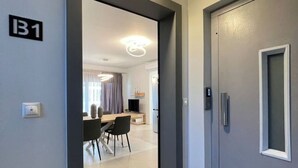 Un interior moderno con una zona de comedor, una puerta gris y un interruptor de luz.