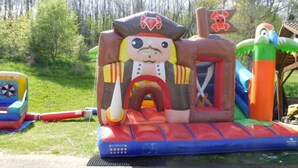 Una estructura inflable amb tema de pirata, que inclou un tobogan i una petita barca.