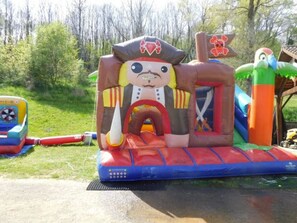 Una estructura inflable con temática de piratas, con un tobogán y un pequeño barco.